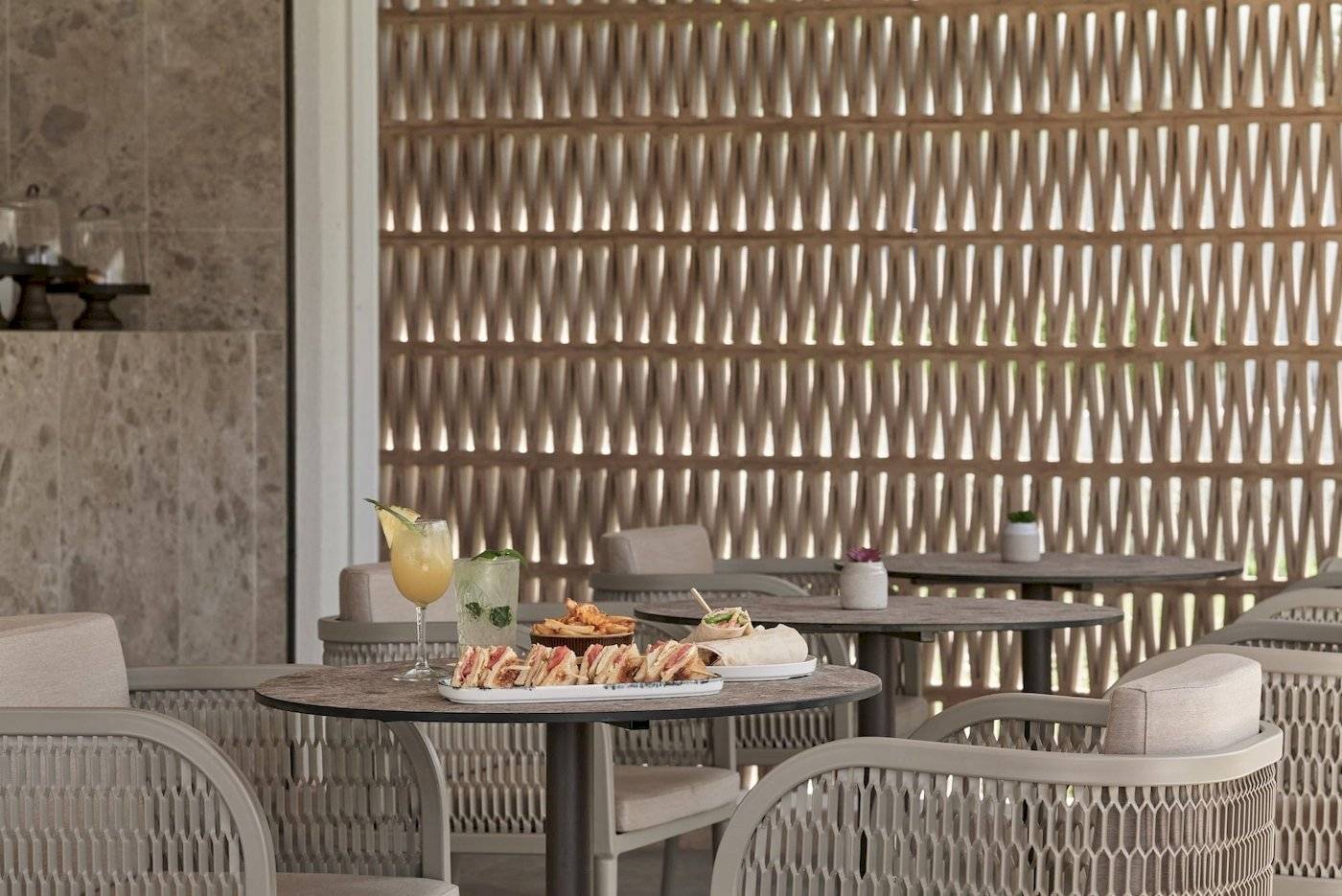 Frühstückstisch auf der Terrasse des Atlantica Beach Resort Kos mit Sandwiches und Getränken.