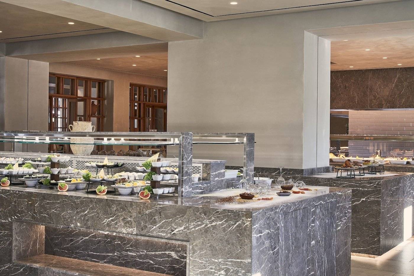 Speisebereich des Atlantica Beach Resort Kos mit Marmortheke und verschiedenen Speisen.
