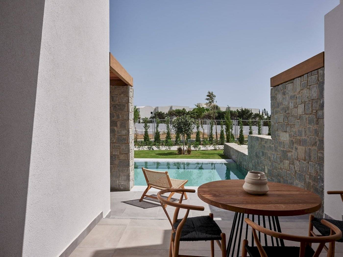 Terrasse mit Tisch und Stühlen und Blick auf den Pool im Atlantica Beach Resort Kos