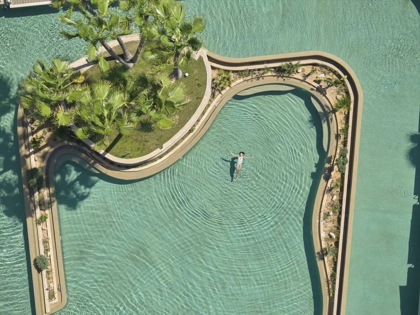 Person schwimmt in der Infinity-Pool-Landschaft des Atlantica Beach Resort Kos.