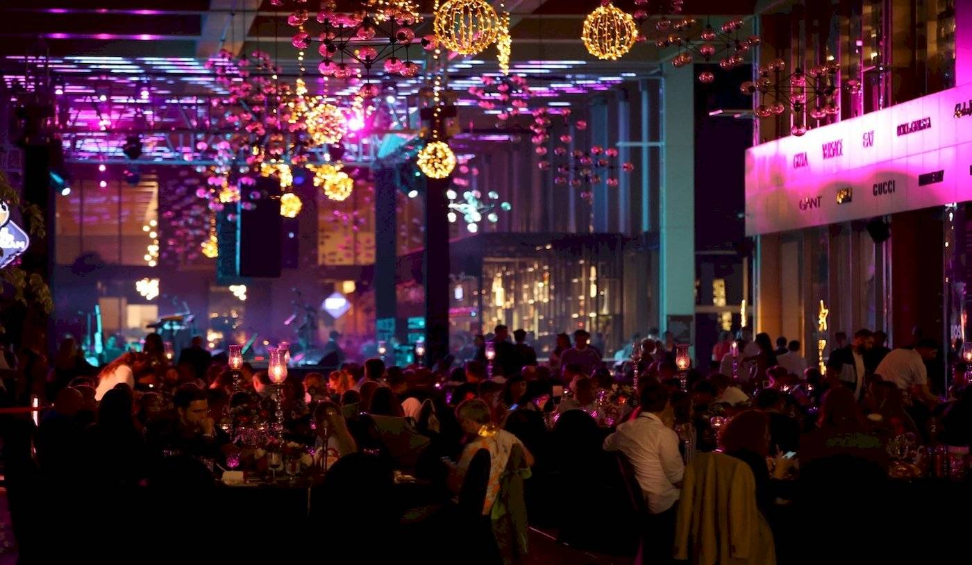 Eine Nachtveranstaltung im Nirvana Cosmopolitan Hotel mit vielen Gästen und leuchtenden Dekorationen.