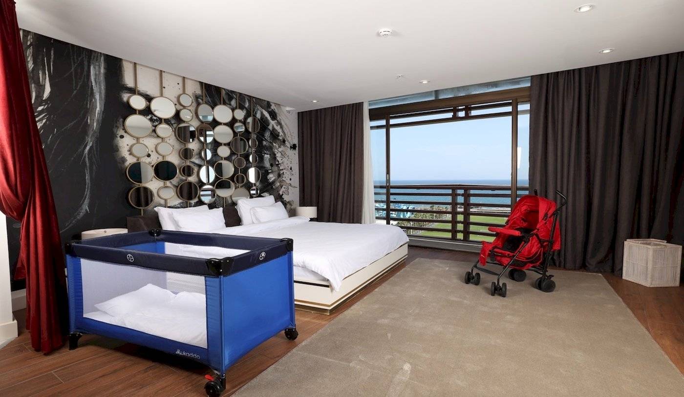 Nirvana Cosmopolitan Hotel Zimmer mit Bett und Kinderwagen am Meer