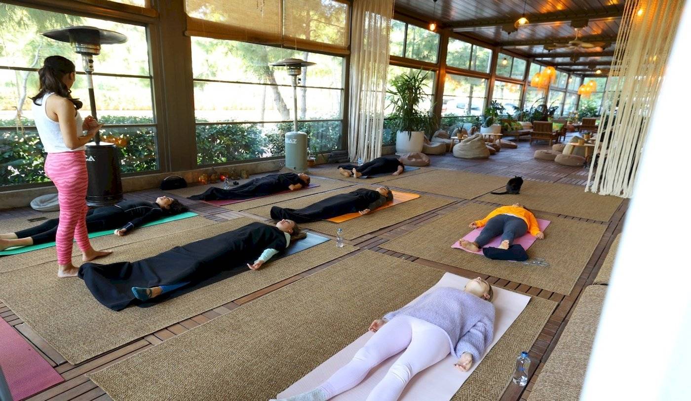 Gruppe von Menschen, die im Nirvana Cosmopolitan Hotel Yoga üben, mit einer Lehrerin in der Mitte.