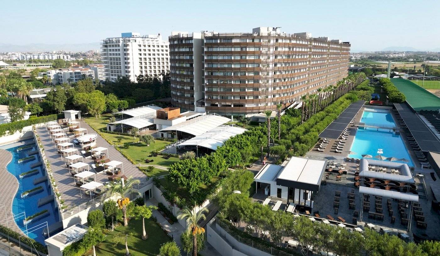 Luftaufnahme des Nirvana Cosmopolitan Hotels mit Swimmingpool und umliegenden Gebäuden.