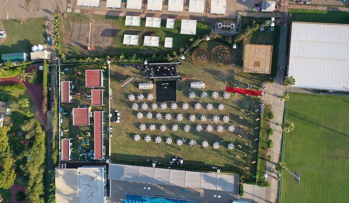 Luftaufnahme des Nirvana Cosmopolitan Hotels Veranstaltungsbereich mit Zelten, Sitzgruppen und Bühne.