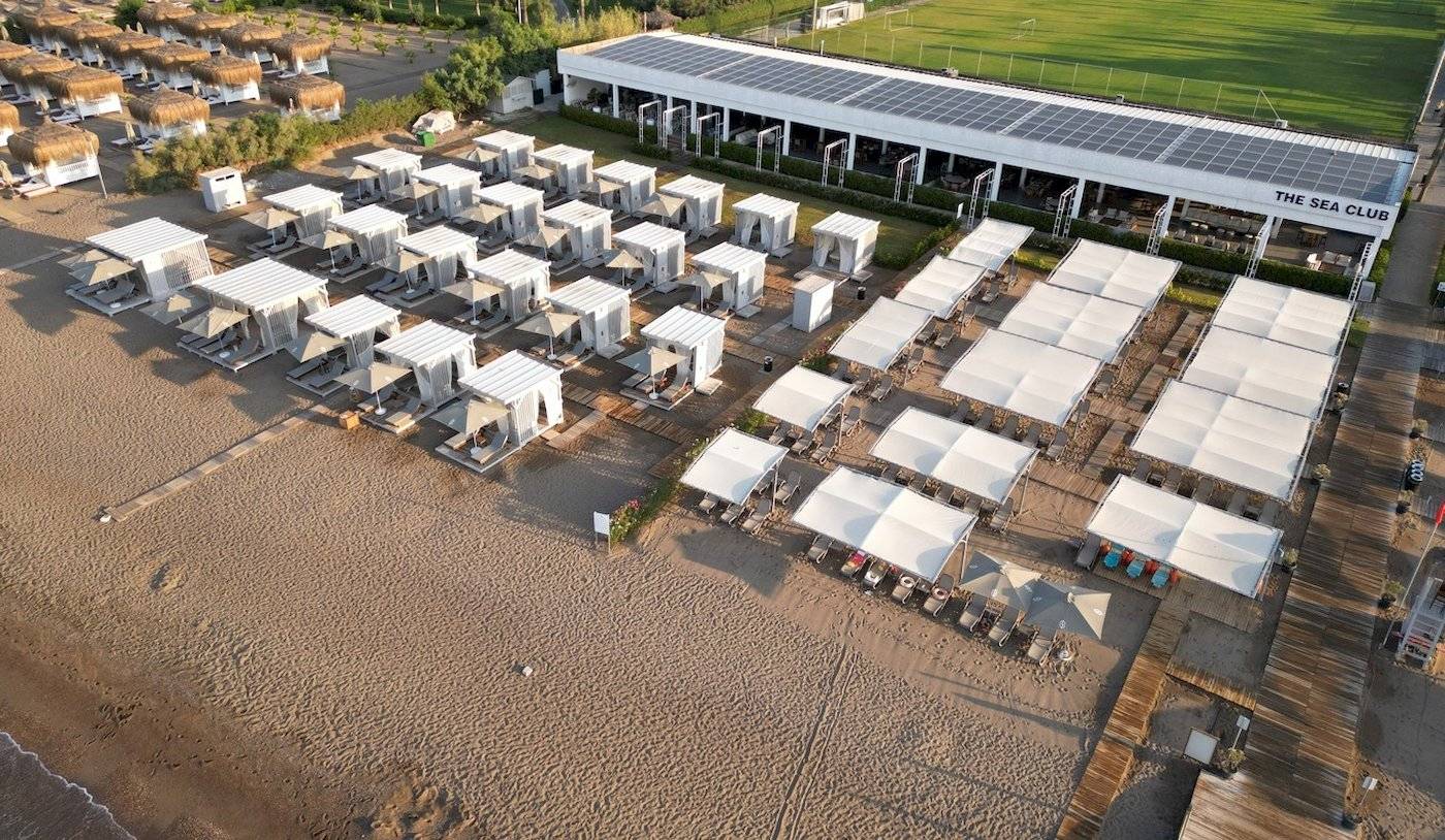 Luftaufnahme des Nirvana Cosmopolitan Hotels mit weißen Zelten und Solarmodulen am Strand