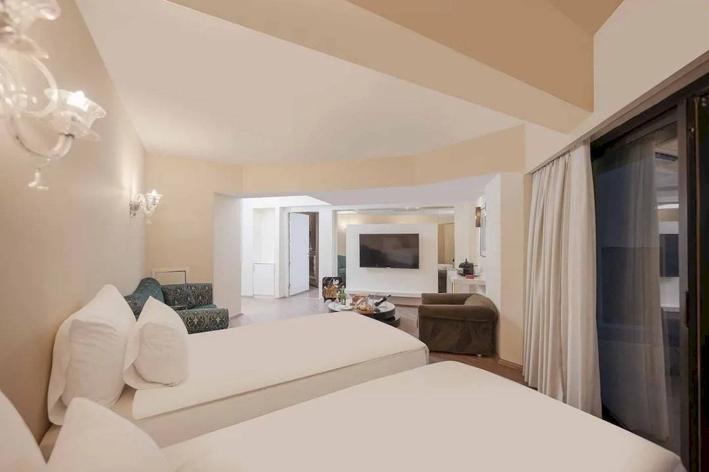 Doppelzimmer im Megasaray Resort Side mit zwei Betten, Fernseher und Sofa.