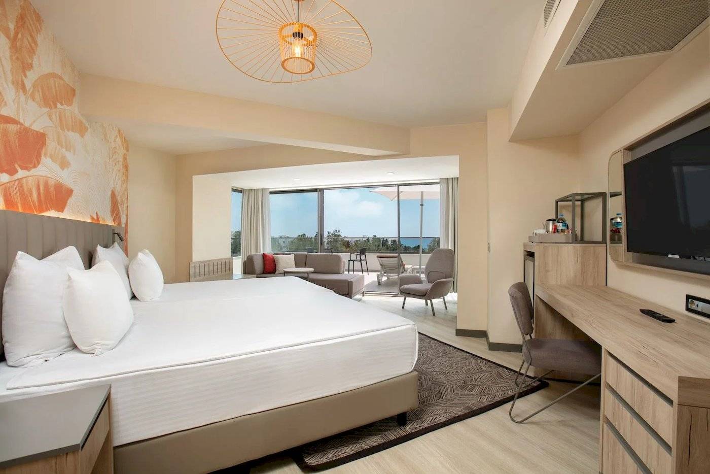 Hotelzimmer im Megasaray Resort Side mit großem Bett, Wohnzimmerbereich und Blick auf den Balkon.