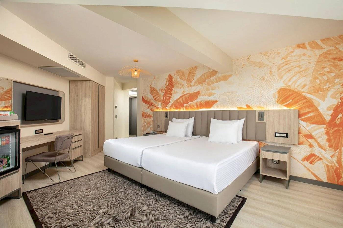 Doppelzimmer im Megasaray Resort Side mit zwei Betten, Fernseher, Schreibtisch und tropischen Wandmustern.