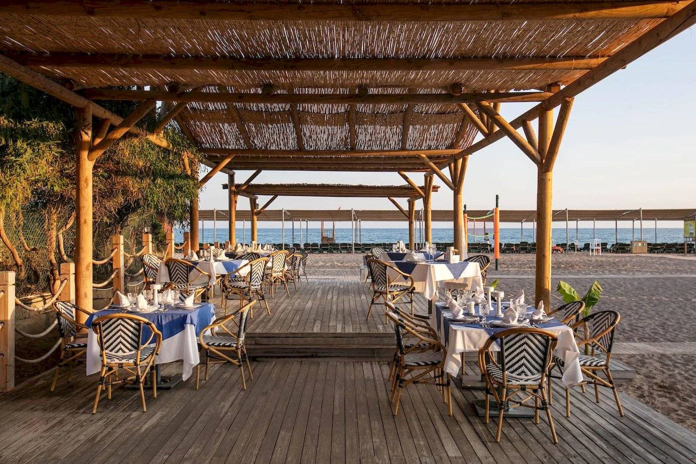 Restaurant am Strand des Megasaray Resorts in Side mit gedeckten Tischen und Stühlen.