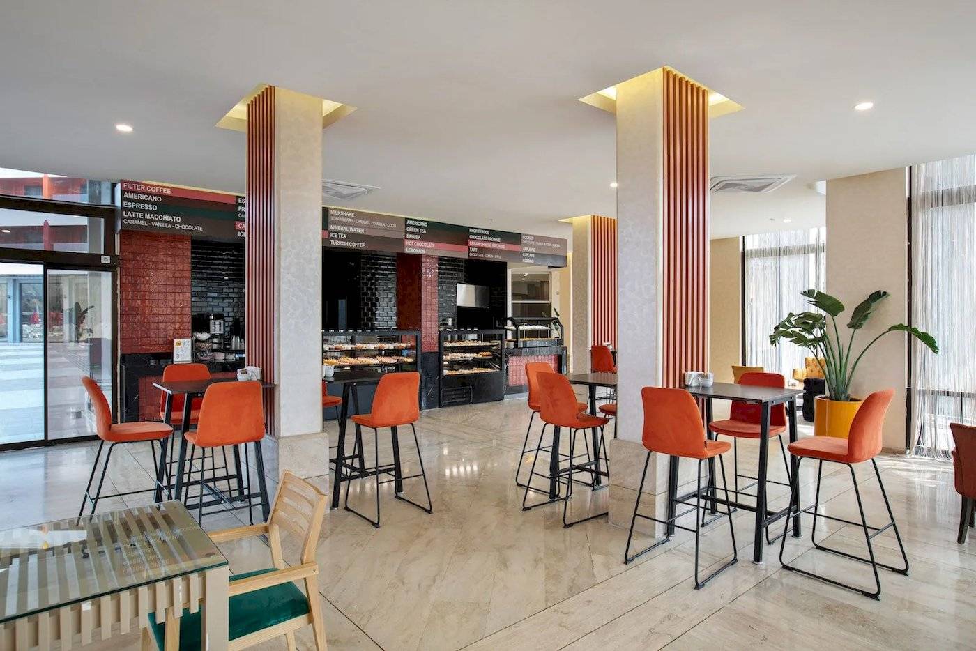 Megasaray Resort Side Hotel Café mit orangen Stühlen und Tischen.