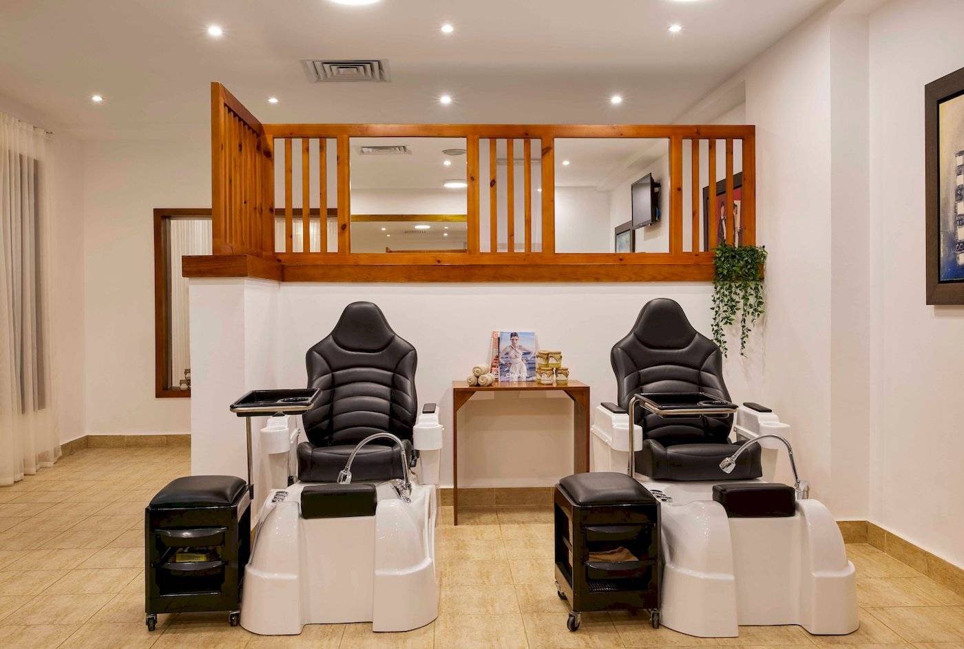 Innenbereich des Schönheitssalons im Jaz Grand Marsa Hotel mit zwei Fußpflegestühlen und einer kleinen Tischkonsole.