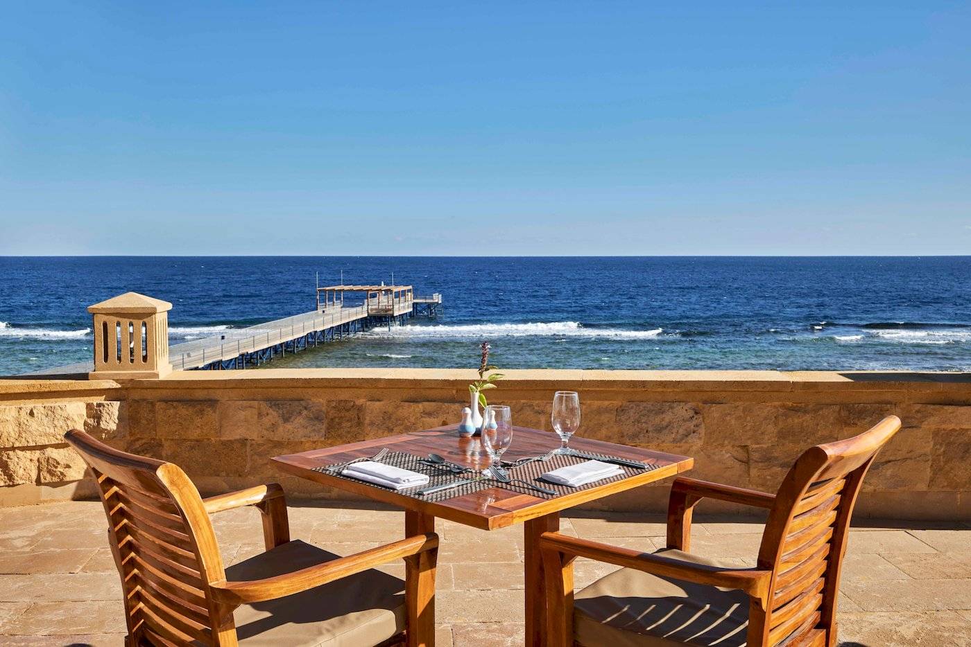 Außenbereich des Jaz Grand Marsa mit Blick auf das Meer und eine Brücke.
