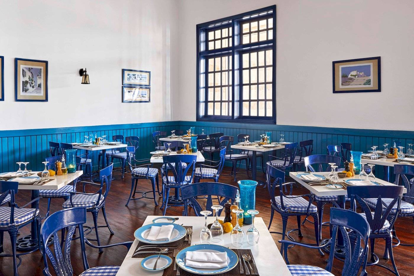 Innenansicht des Restaurants im Jaz Grand Marsa Hotel mit blauen Stühlen und Tischen.