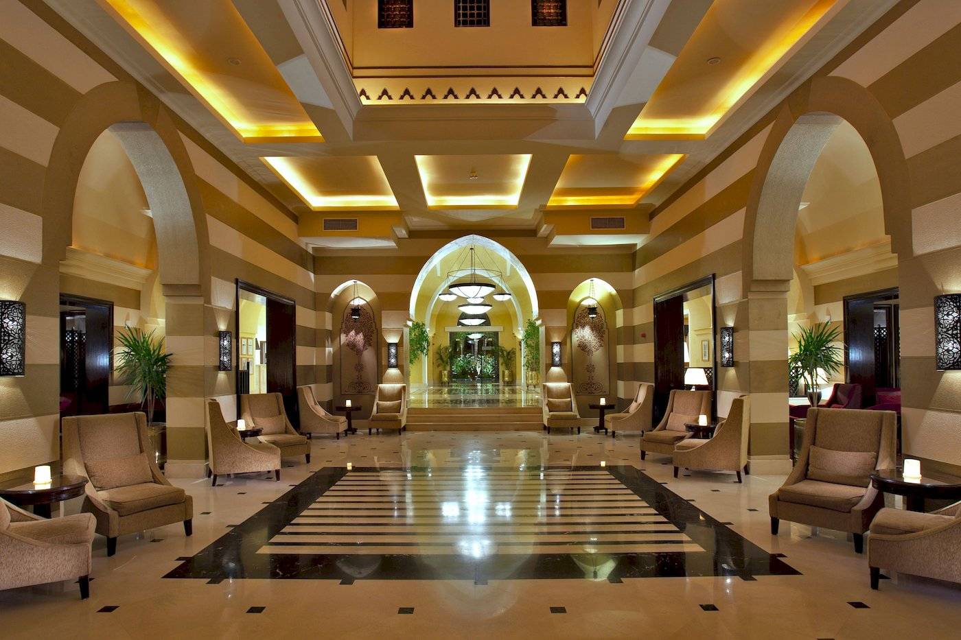 Empfangsbereich des Jaz Lamaya Resorts mit gepolsterten Stühlen und Tischlampen.