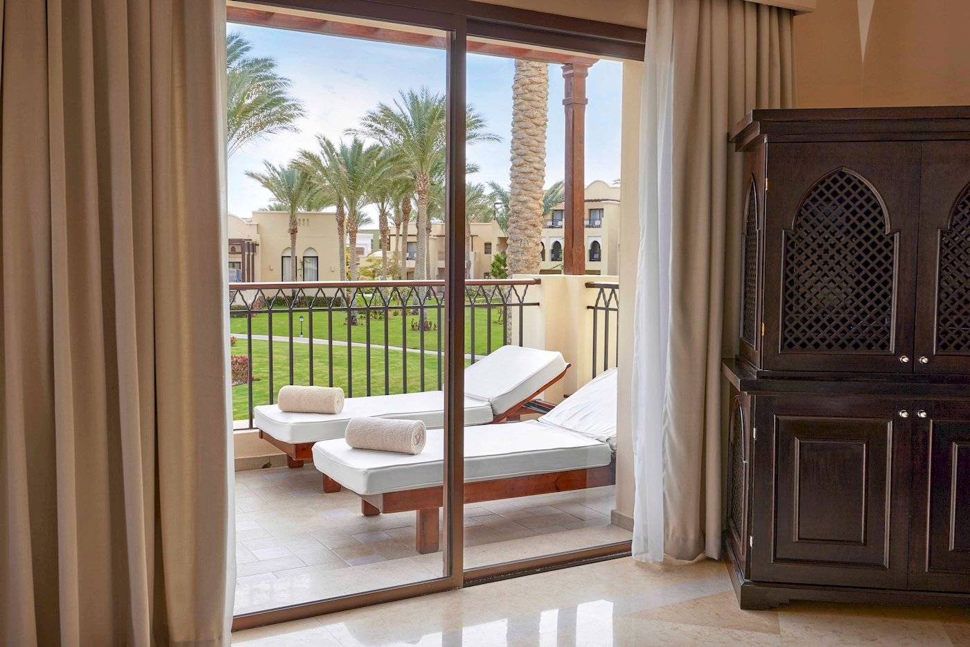 Blick von einem Balkon des Jaz Lamaya Resorts auf zwei Liegen mit Handtüchern.