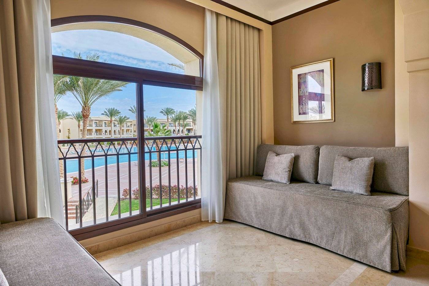 Suite im Jaz Lamaya Resort mit Balkon und Blick auf den Pool.