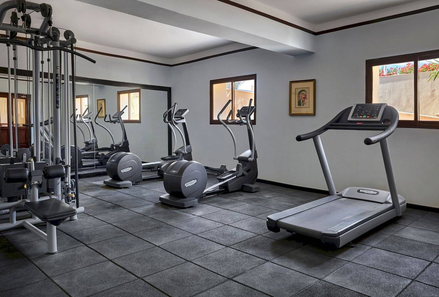Fitnesscenter im Jaz Lamaya Resort mit mehreren Geräten und Fenstern.