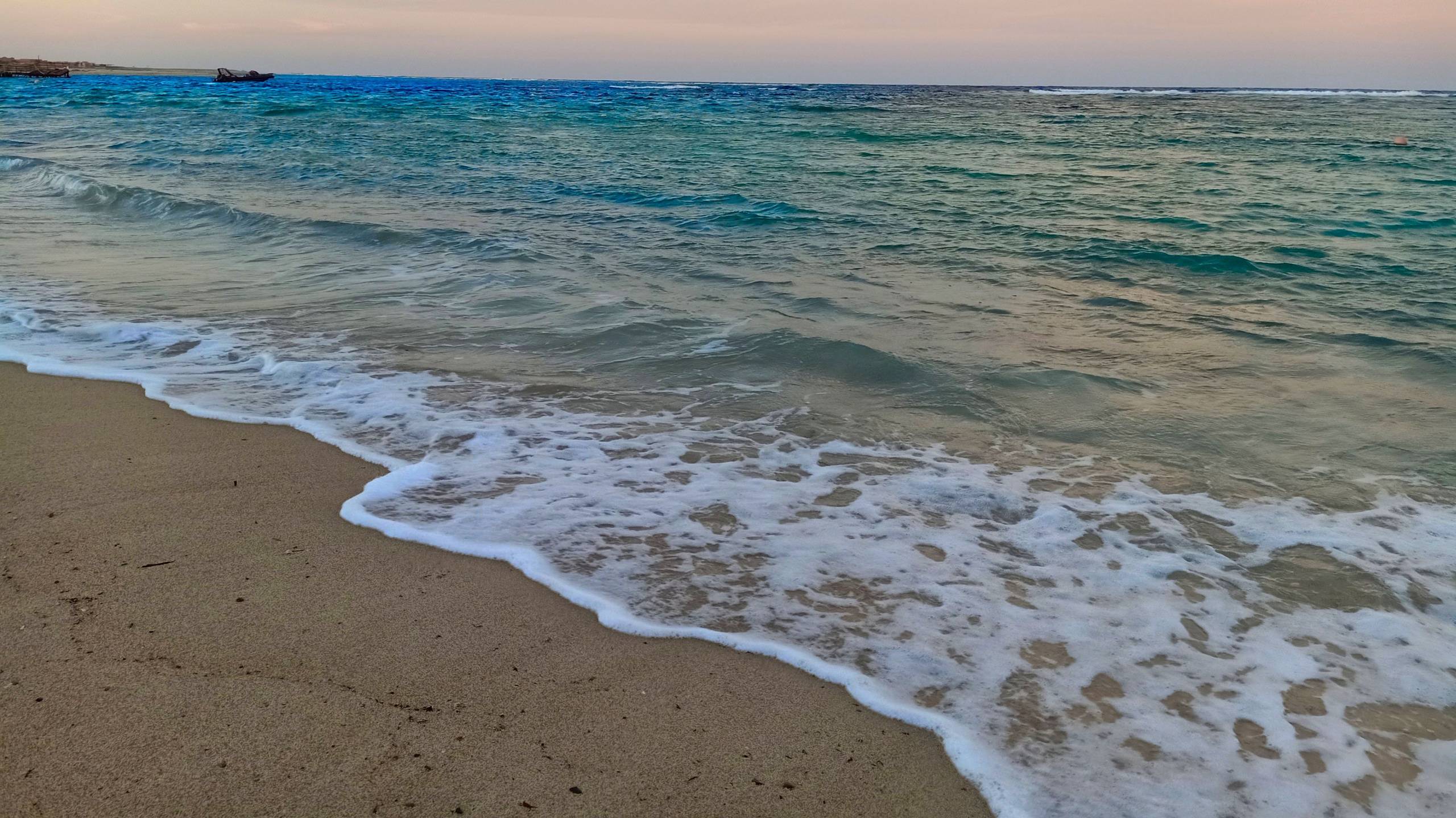 Foto vom Utopia Beach Club zeigt das Meer am Abend mit sanften Wellen am Strand.