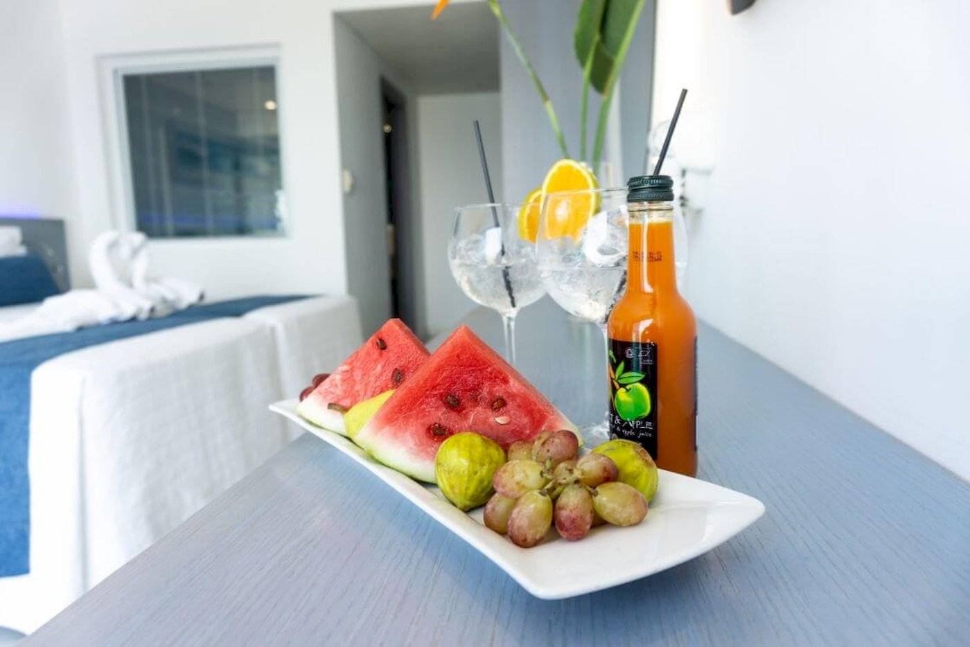 Frühstücksplatte mit Wassermelonen, Feigen, Trauben und Getränken im Anonymous Beach Hotel.