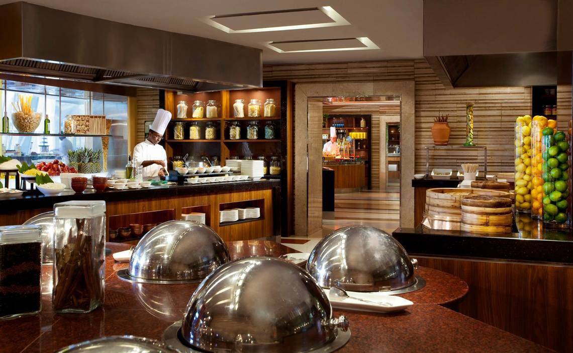 Restaurantbuffet im Jumeirah Beach Hotel mit einem Koch, der Gerichte vorbereitet.