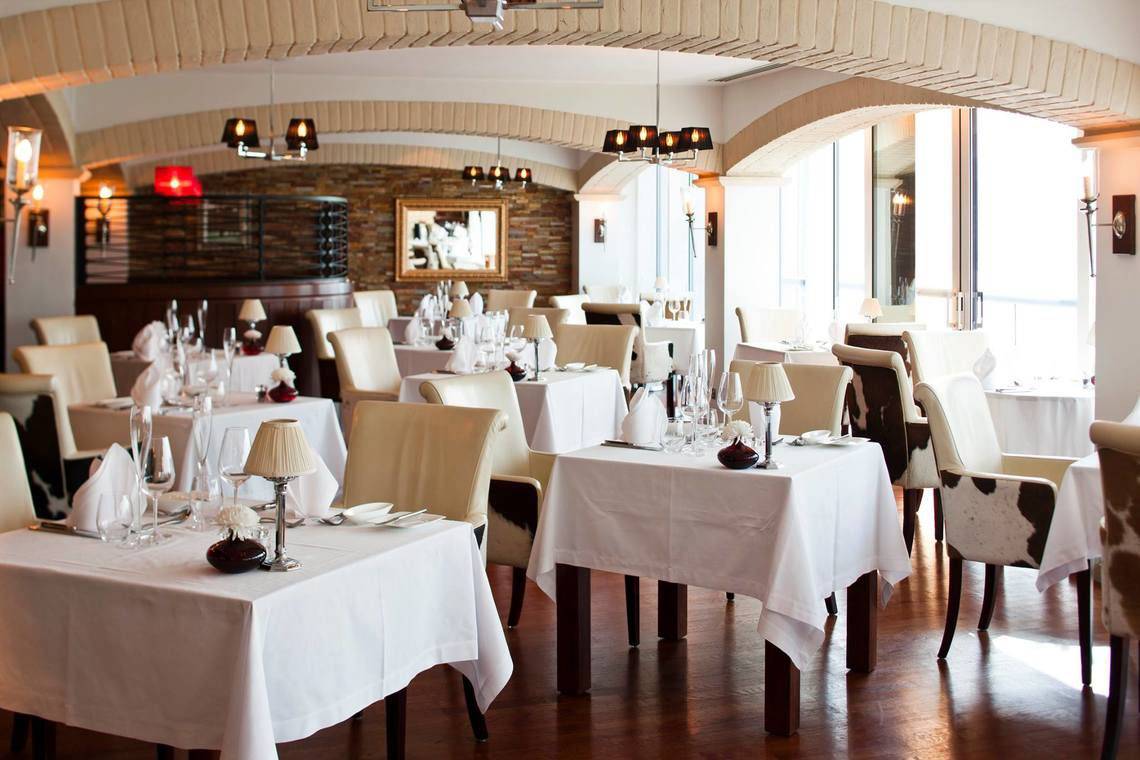 Innenansicht des Restaurants im Jumeirah Beach Hotel mit gedeckten Tischen und eleganter Einrichtung.