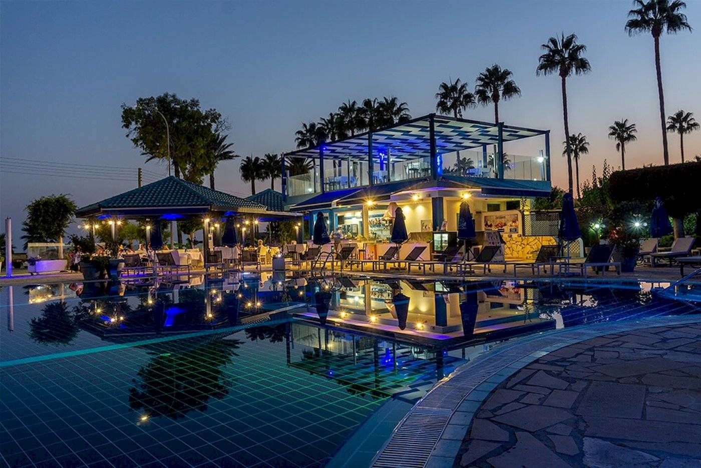 Ein Pool mit einer Loungebar im Anonymous Beach Hotel bei Nacht.