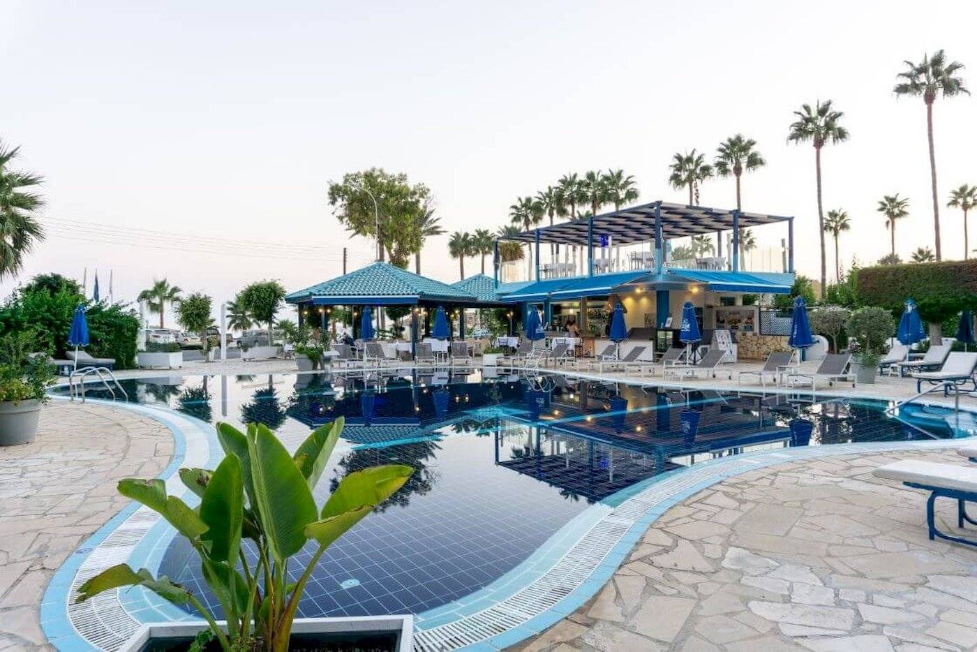 Außenpool des Anonymous Beach Hotels mit Lounge-Stühlen und Sonnenschirmen.