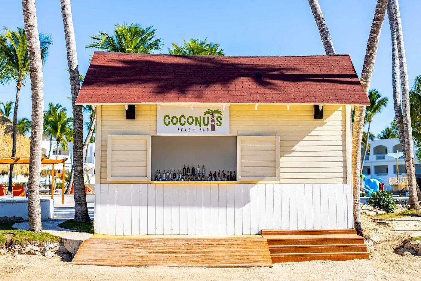 Coconuts Beach Bar im Sunscape Dominicus La Romana mit vielen Flaschen und tropischen Palmen im Hintergrund