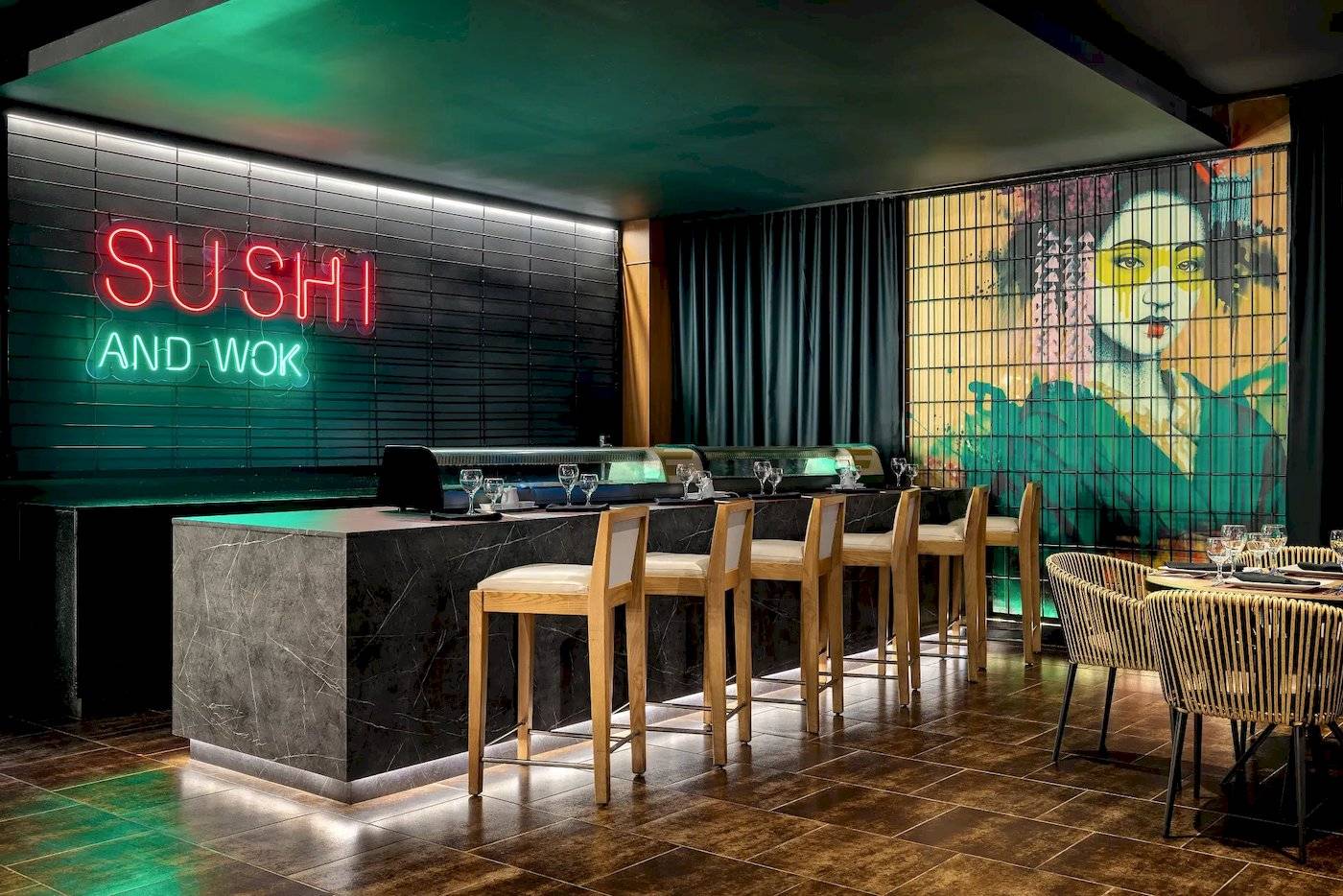 Innenansicht des Sushi und Wok Restaurants im Sunscape Dominicus La Romana mit einer neonroten Beleuchtung und einer Wandmalerei.