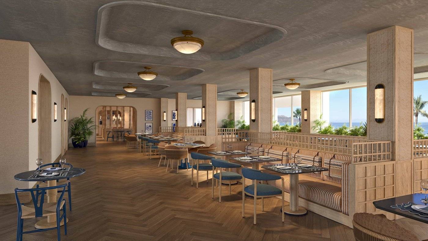 Innenansicht des Restaurants im Atlantica Kalliston Resort mit Holzboden und großen Fenstern.