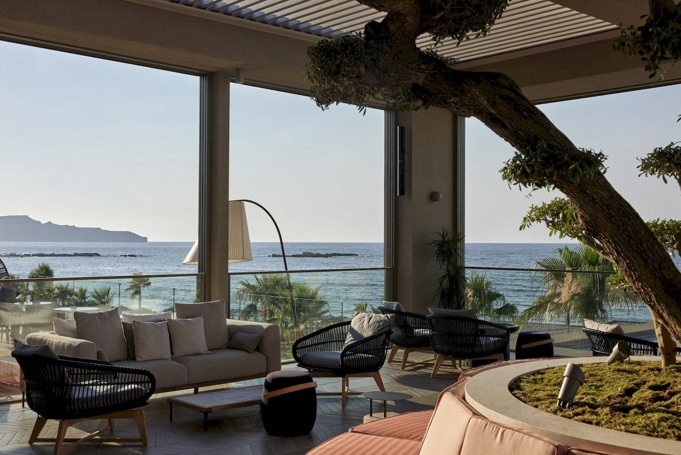 Innenbereich des Atlantica Kalliston Resorts mit Blick auf das Meer und moderne Möbeln.