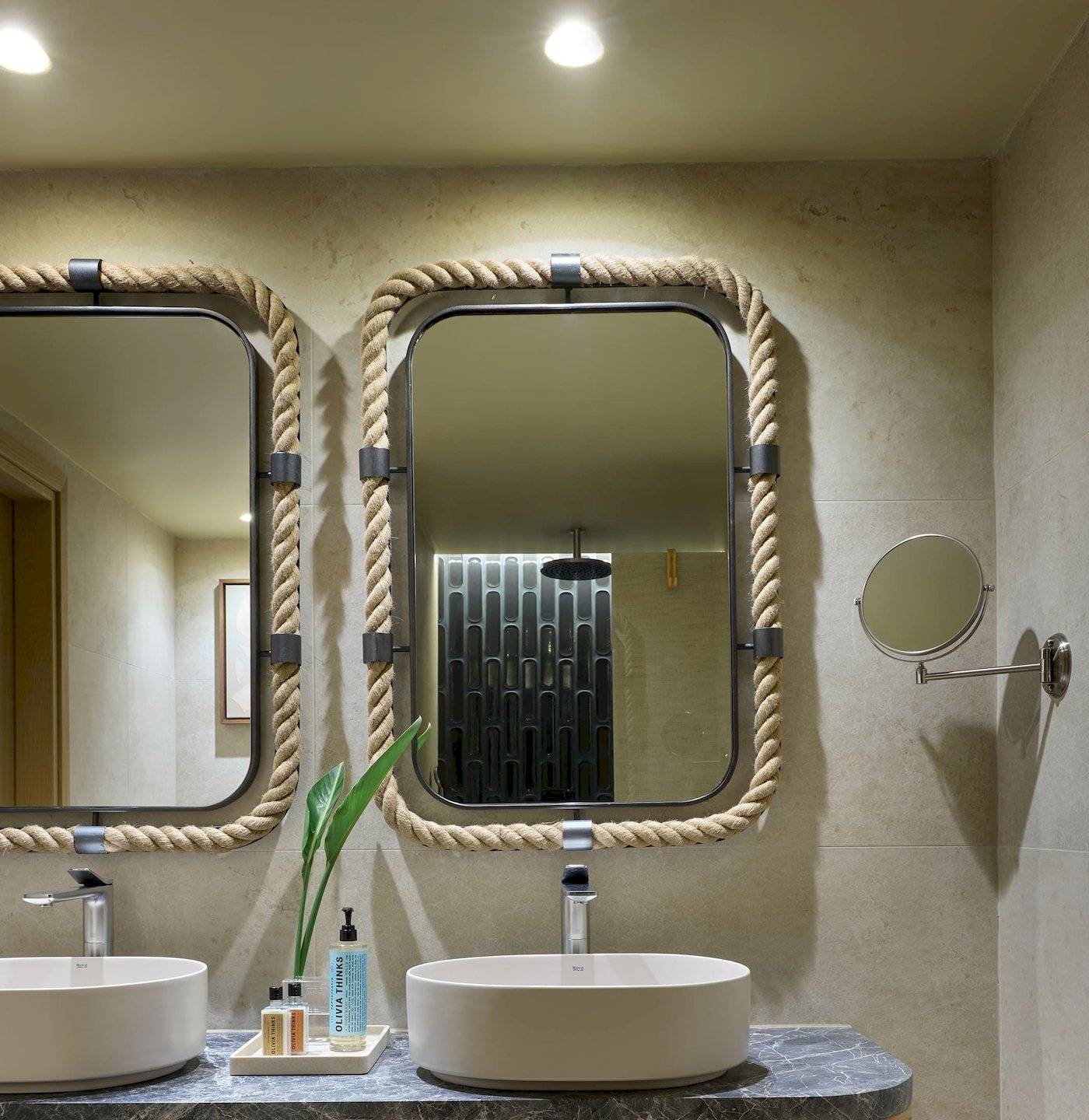 Badezimmer des Atlantica Kalliston Resorts mit zwei Waschbecken und Spiegeln.