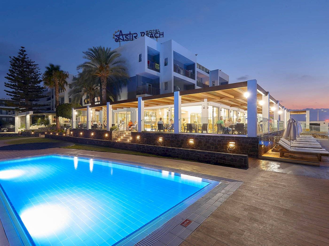 Pool im Freien neben dem Astir Beach Hotel in Kreta, das bei Nacht geöffnet ist.