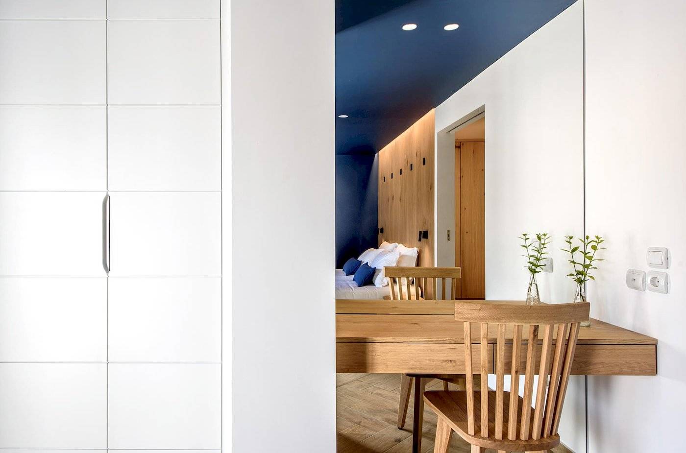 Interieur des Arminda Hotel & Spa Zimmers mit Bett, Schreibtisch und Garderobe.