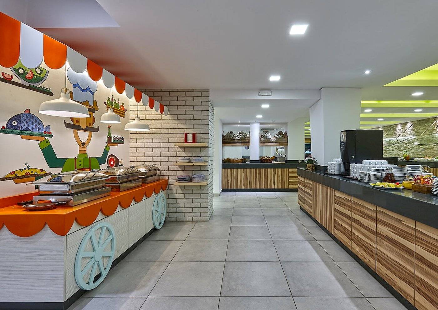 Frühstücksbereich im Arminda Hotel & Spa mit gedeckten Tischen, Buffet-Stationen und farbenfroher Wandgestaltung.