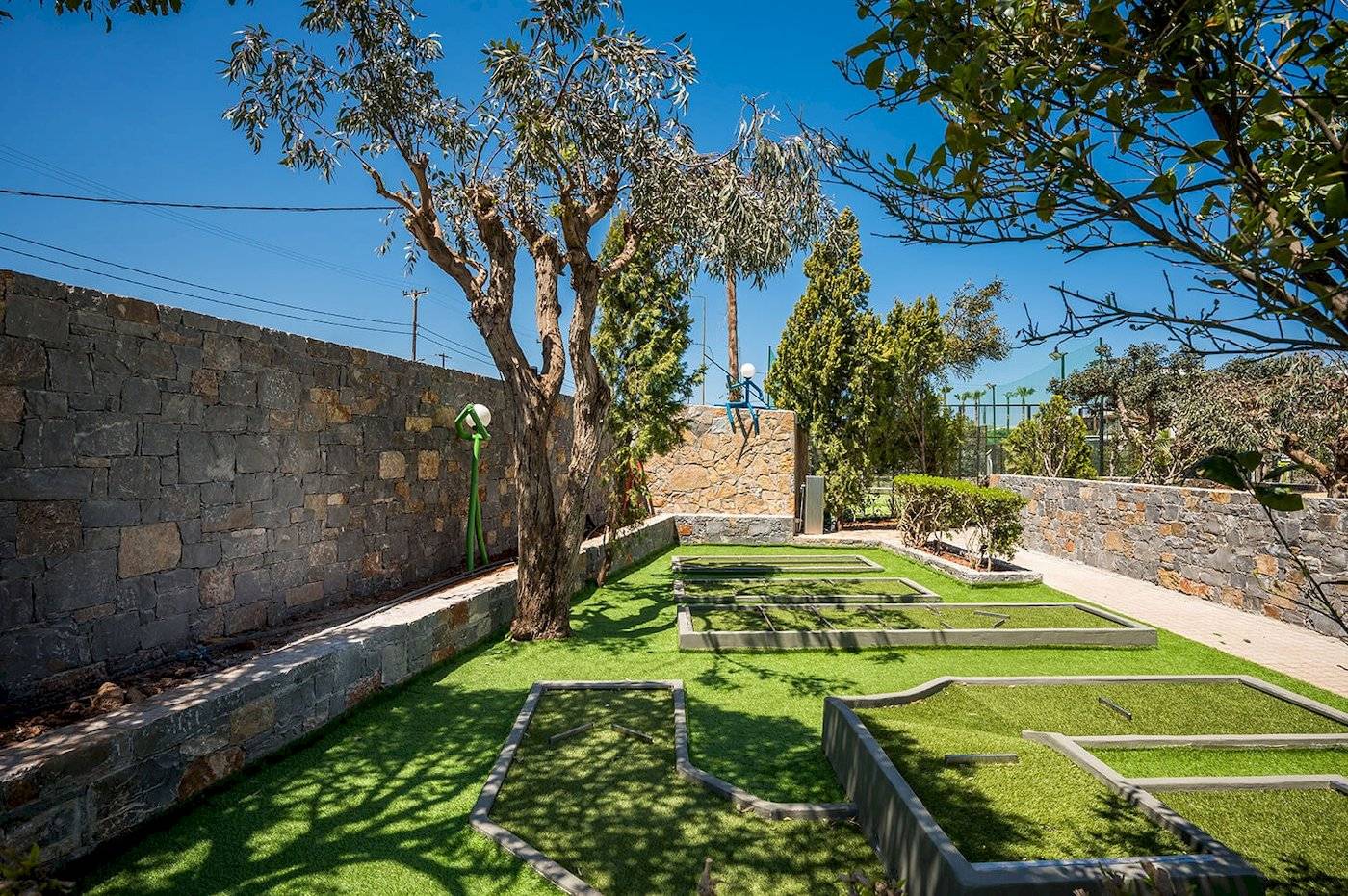 Golfplatz am Arminda Hotel & Spa mit grünem Rasen und Steinmauern