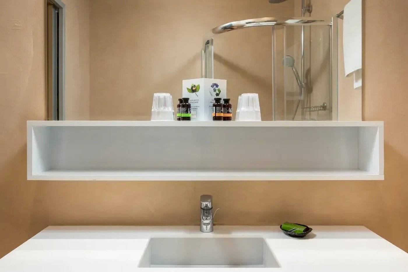 Badezimmer im Corissia Beach Hotel mit Dusche und Waschbecken.