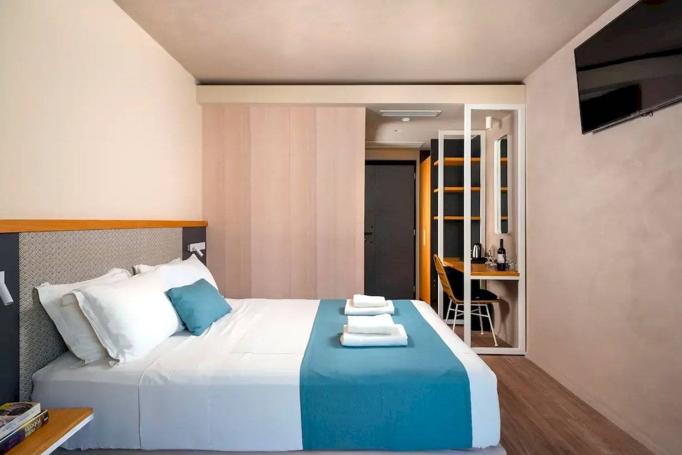 Ein Schlafzimmer im Corissia Beach Hotel mit einem großen Bett und blauen Kissen.