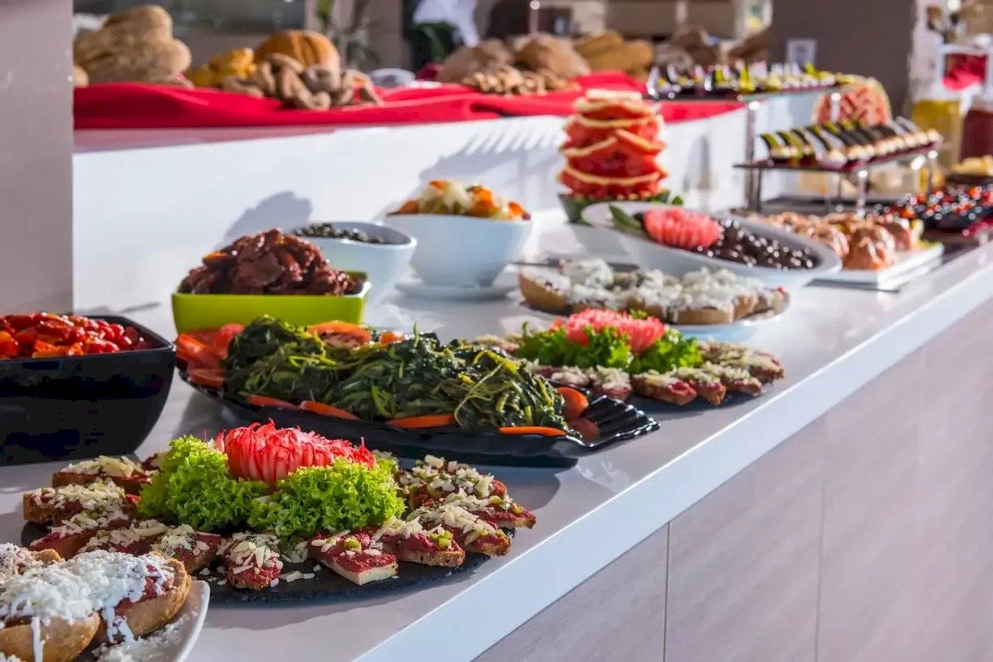 Buffet im Corissia Beach Hotel mit verschiedenen Speisen auf einem langen Tisch.