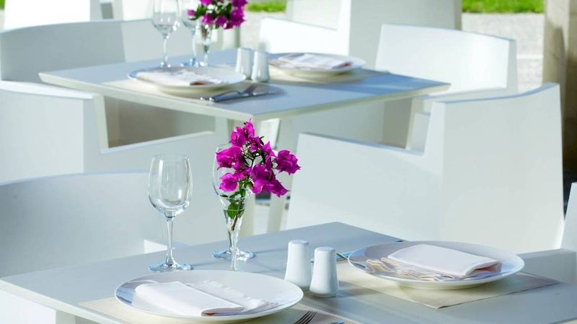 Restauranttisch des Sheraton Rhodes Resort mit Tischdeko und serviertem Geschirr.