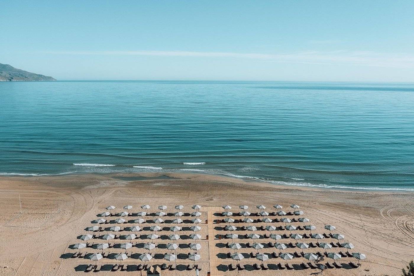 Luftaufnahme des Eliros Mare Hotels mit Sonnenschirmen auf dem Strand