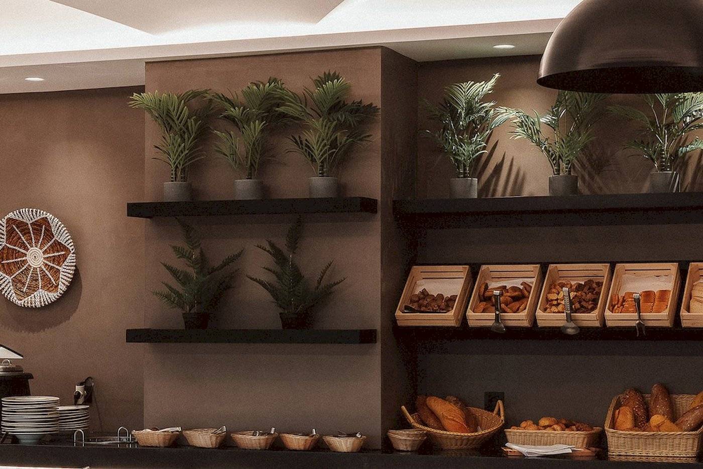 Frühstücksbuffet im Eliros Mare Hotel mit Brotkörben und Pflanzen.