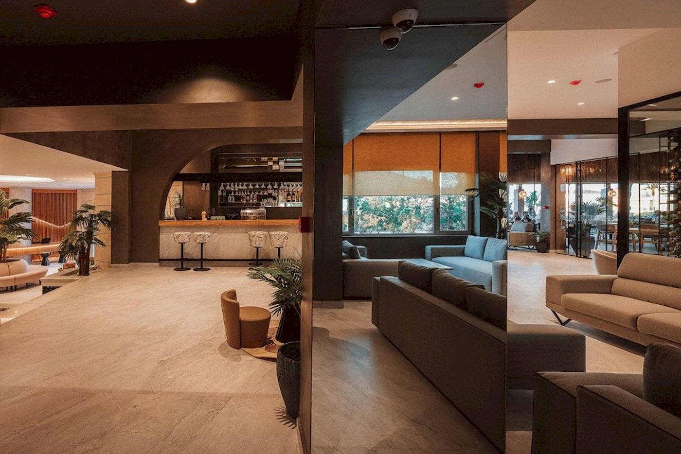 Innenbereich des Eliros Mare Hotels mit Bar, Sofas und Pflanzen.