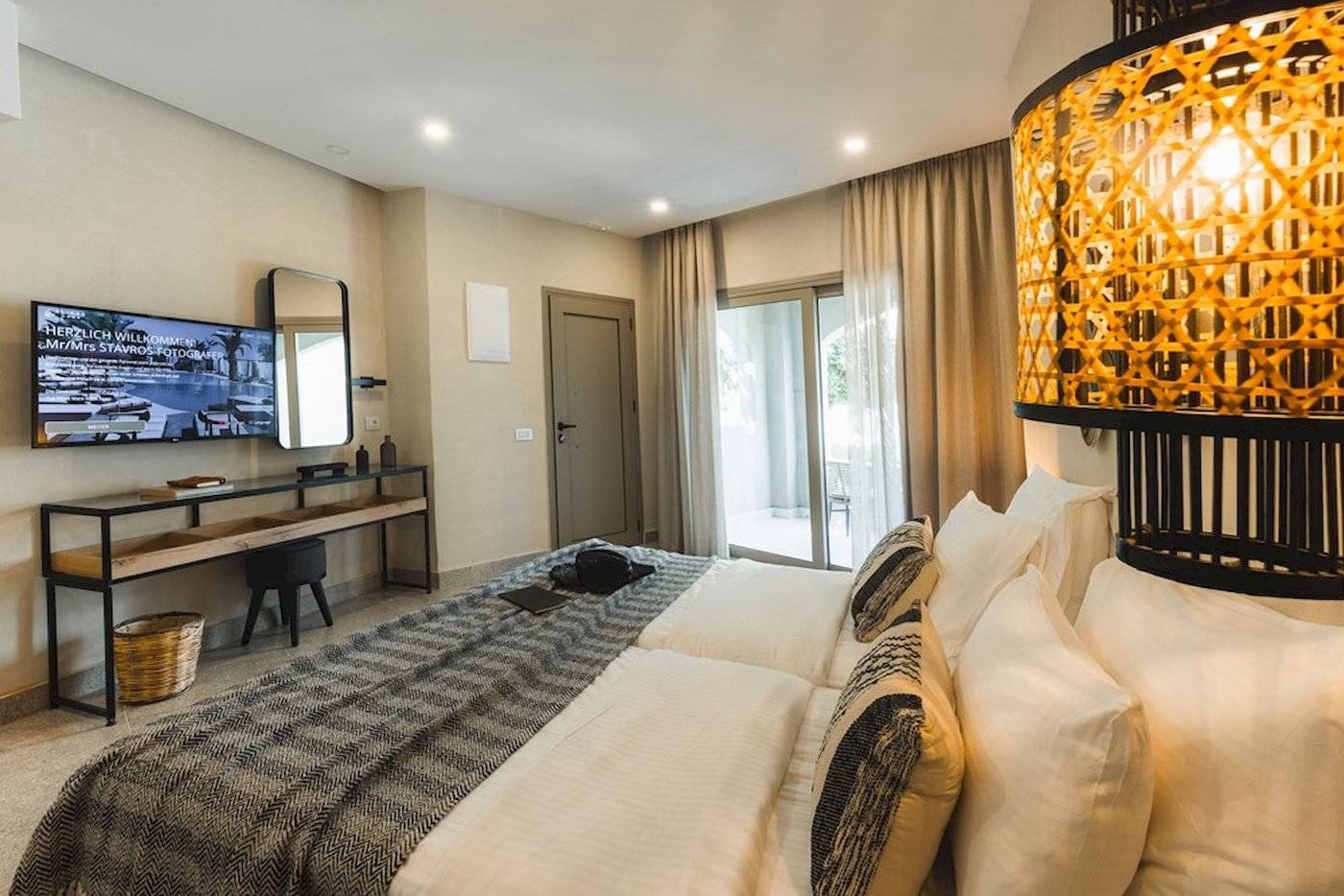 Schlafzimmer im Eliros Mare Hotel mit einem Doppelbett, Fernseher und Schreibtisch.