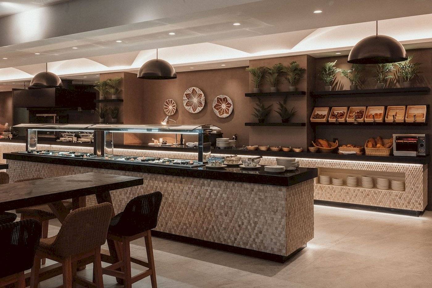 Frühstücksbuffet im Eliros Mare Hotel mit Tisch, Stühlen, Pflanzen und Speisen