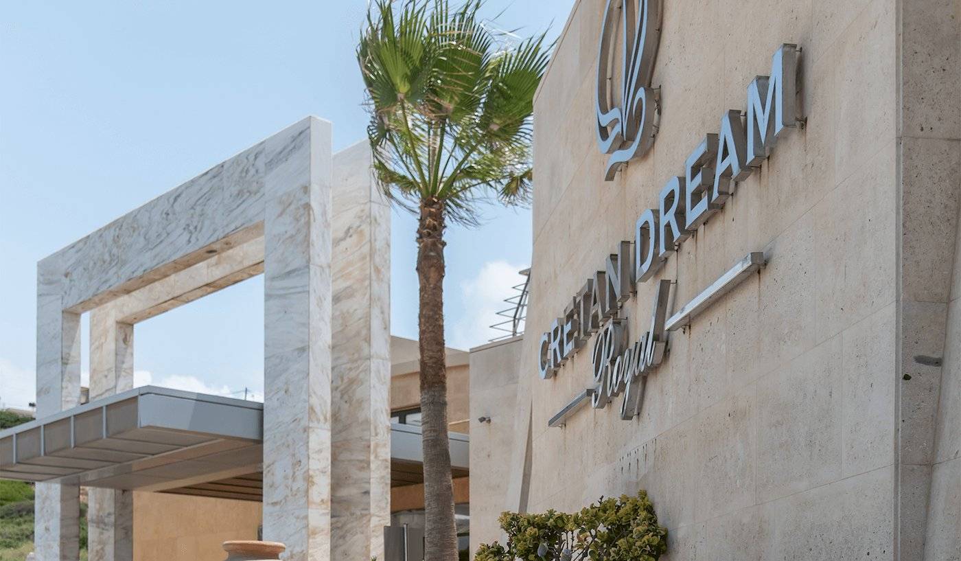 Eingang des Cretan Dream Resort & Spa mit Palme und moderner Architektur