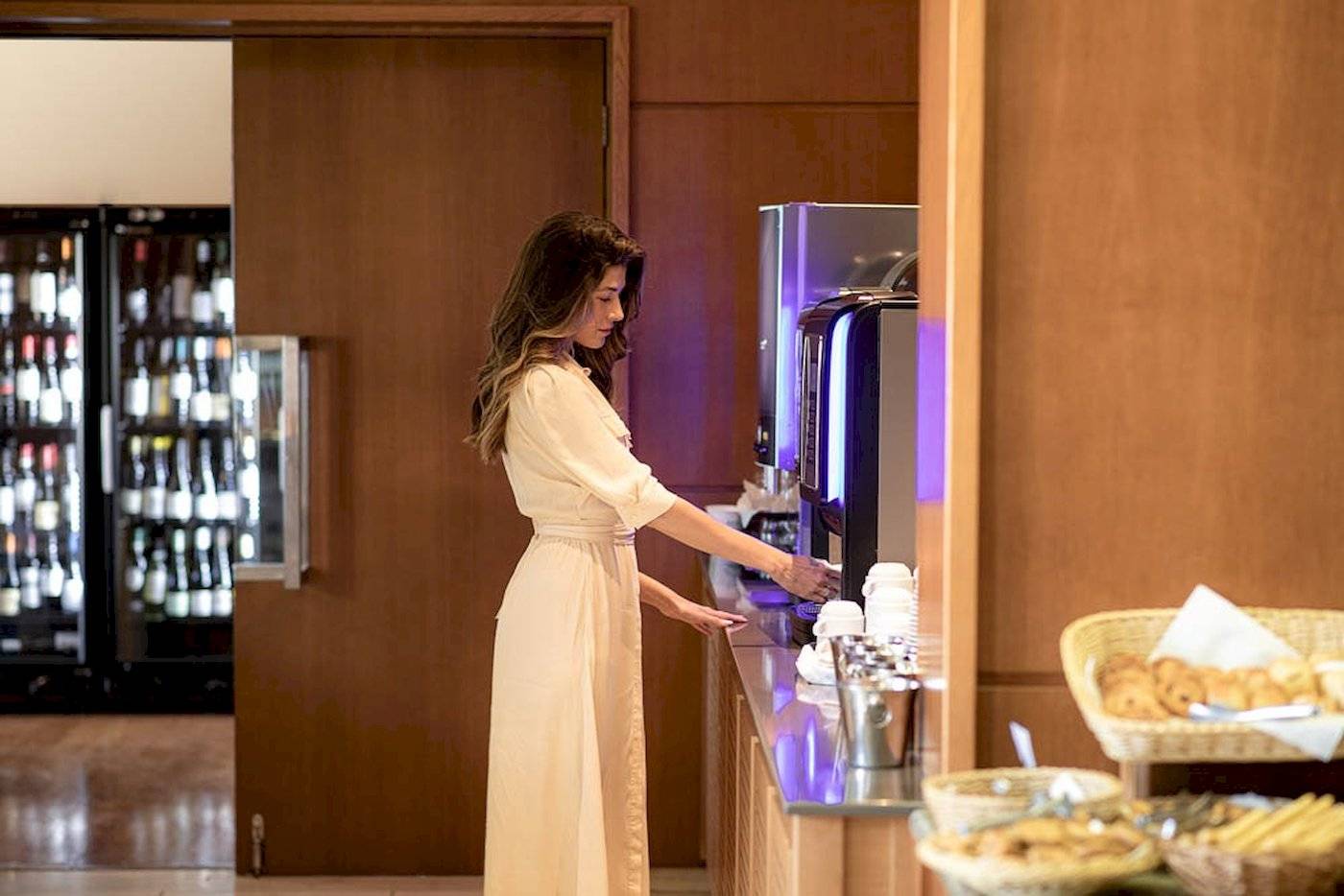 Frau am Kaffeeautomaten im Hotel Cretan Dream Resort & Spa