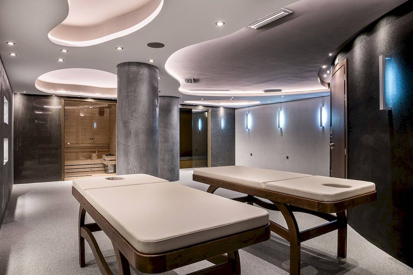 Massageraum im Cretan Dream Resort & Spa mit zwei Massagetischen und einer Sauna.