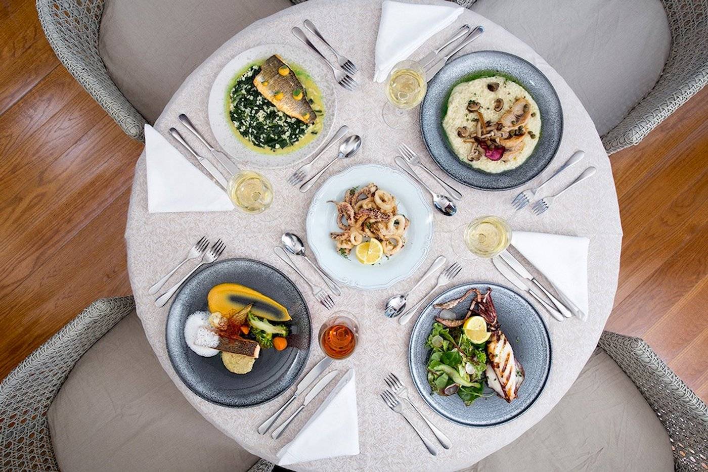 Foto von mehreren Tellern mit Gerichten auf einem Tisch im Cretan Dream Resort & Spa.